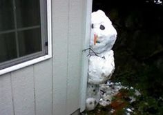 a snowman is sticking its head out the side of a house