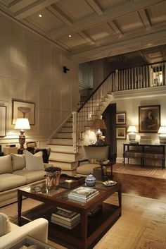 a living room filled with furniture and a stair case in the center of the room