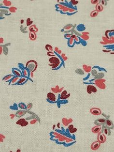 the fabric has red, blue and white flowers all over it's surface on top of an off - white background