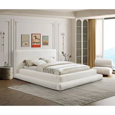 a large white bed sitting in a bedroom next to a window