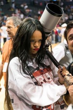 a woman is holding a microphone while standing next to a man on the basketball court