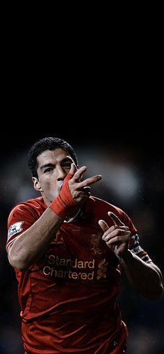 a soccer player is holding his hand up in the air and making a gesture with his right hand