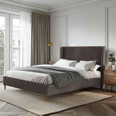 a bedroom with a bed, nightstands and large windows in the room that has wooden flooring