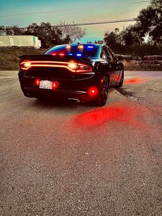 a police car parked on the side of the road with its lights on and flashing