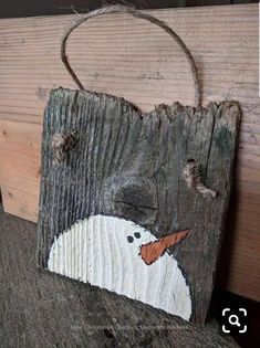 a piece of wood with a snowman painted on it's face and nose