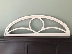 a white headboard on top of a wooden dresser