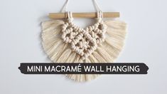 the macrame wall hanging is hung on a wooden hanger with text that reads mini macrame wall hanging