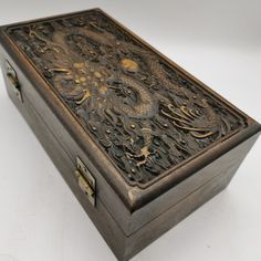 an intricately carved wooden box sits on a white surface