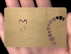 a hand holding a gold business card with an image of a heart on the front