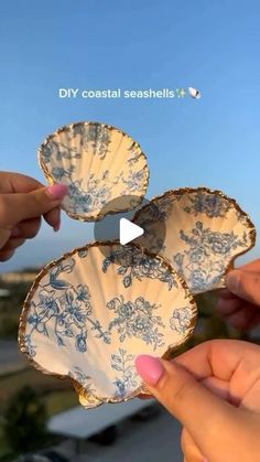 two people holding plates with blue flowers on them and one is pointing to the other