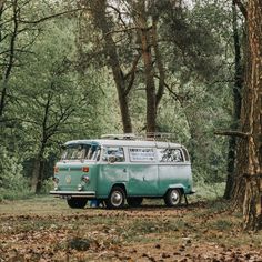 an old vw bus parked in the woods