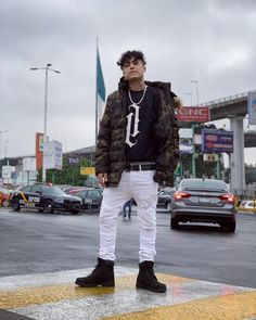 a man standing in the middle of a crosswalk wearing white pants and a black t - shirt