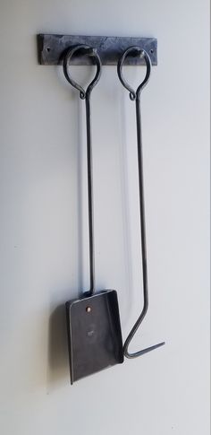 a pair of scissors hanging on the wall next to a square box with a handle