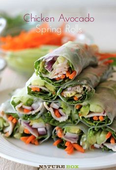 there are many rolls on the plate with carrots and lettuce in them