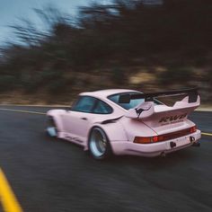 a pink sports car driving down the road