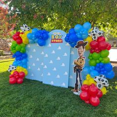 the balloon arch is decorated with an image of woody from toy story and some balloons