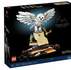 the harry potter owl is sitting on top of books and has its wings spread out