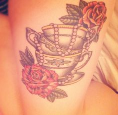 a woman's thigh with tattoos on it and a tea cup in the middle