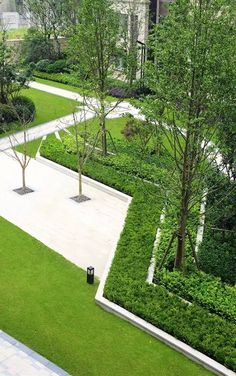 an aerial view of a garden with trees, shrubs and walkways in the center