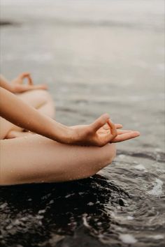 a woman sitting in the water with her hands together