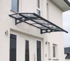 a white house with a black awning over the front door