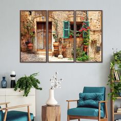 three paintings on the wall of a living room with blue chairs and potted plants