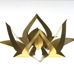 an artistic sculpture made out of gold paper on a white background with the shape of a flower