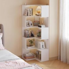 a white book shelf sitting on top of a bed next to a window in a bedroom