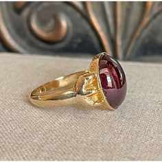 Step back to a time of refined elegance with this Victorian Garnet Signet Ring, a splendid piece that exudes the charm of the early 19th century. This impressive ring features a large cabochon garnet, measuring 14.4x11.5 mm, set in a distinctive signet style. The garnet is closed backed, emphasizing its rich, deep color and classic appeal.  Originally crafted around 1840-50, the ring has been expertly re-shanked; while the top mounting and the intricately detailed clawed feet are made of 15 kara Victorian Garnet Ring, Victorian Yellow Gold Cabochon Ring, Luxury Victorian Style Cabochon Ruby Ring, Victorian Garnet Gemstone Rings, Victorian Garnet Silver Ring, Victorian Style Rings, Gold Cocktail, Gold Cocktail Ring, Cabochon Ring