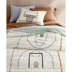 a bed with a basketball themed comforter and pillows on it, along with two pillow cases