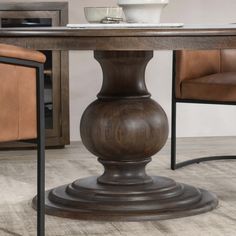 a wooden table with two brown chairs and a white bowl on top of the table