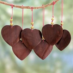 three wooden hearts hanging from a tree branch