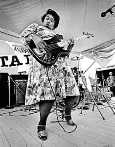 a woman is playing guitar on the stage