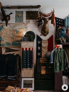 a room filled with lots of different types of clothing and items on the walls, including deer heads