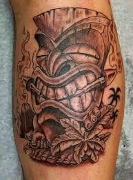 a close up of a person's leg with a tattoo on it and an image of a demon