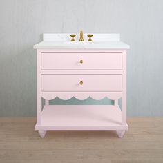 a pink vanity with two gold faucets on it