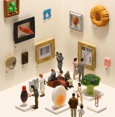 a group of figurines sitting on top of a white table next to pictures