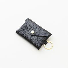 a small black wallet with a gold ring on the front and an id holder in the back