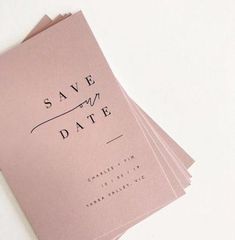 pink wedding save the date cards with black ink on them, set against a white background