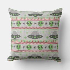 a green and red pillow with aliens on it