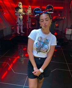 a young woman standing in front of a star wars scene with lights on her head