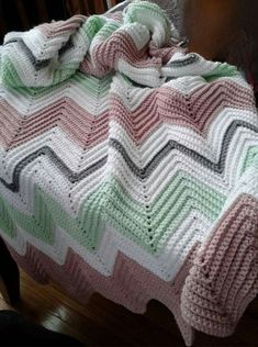 a crocheted blanket sitting on top of a wooden chair