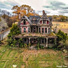 an old abandoned house with ivy growing on the roof and windows, surrounded by autumn foliage