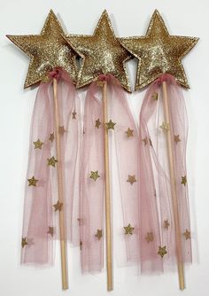 three gold stars on top of pink tulle wands, one with golden glitter