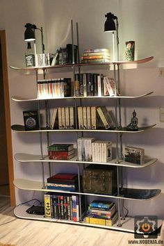 a bookshelf filled with lots of books next to a wall