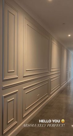 an empty hallway with white walls and wood paneling