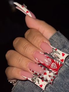 a woman's hand with pink and white nail designs on it, holding onto her jeans