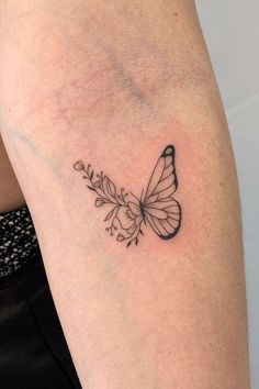 a black and white butterfly tattoo on the arm