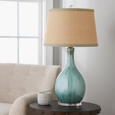 a table with a lamp on it next to a couch