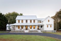 a large white house sitting on top of a lush green field